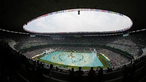 2026 FIFA Dünya Kupası açılış töreninden genel plan, sahne ışıkları ve kalabalık tribünler görülüyor.