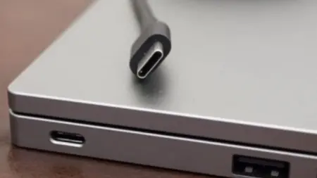 Avrupa Birliği bayrağı önünde dizüstü bilgisayar ve USB-C kablosu