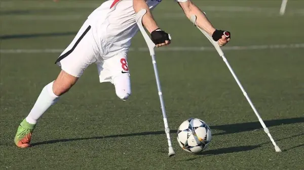 Ampute futbol takımının şampiyonluk kupasını kaldırdığı anı gösteren otantik bir basın fotoğrafı.