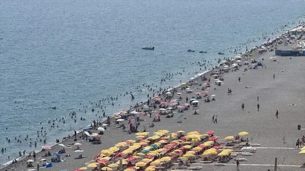 Antalya Konyaaltı Sahili'nde yüksek nem ve sıcaktan bunalan insanlar