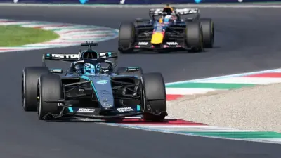 George Russell, Formula 1 Azerbaycan Grand Prix'sinde birincilik kürsüsünde kupasını kaldırırken.