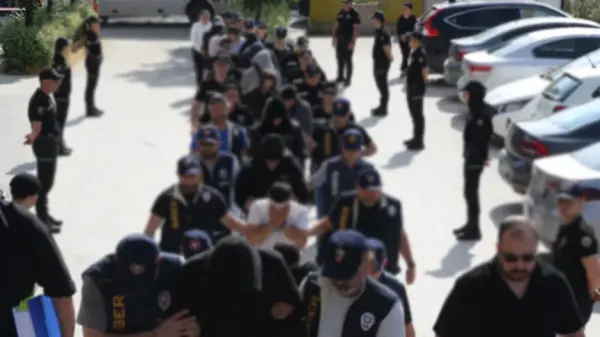 Polis ekipleri, internet dolandırıcılığı şüphelilerine yönelik düzenlenen operasyonda gözaltına alınan zanlıları emniyete getiriyor.