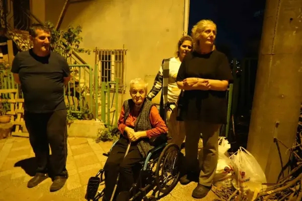 İzmit'te bir evin mutfak tavanından düşen sıva parçaları ve evin dışındaki endişeli aile.