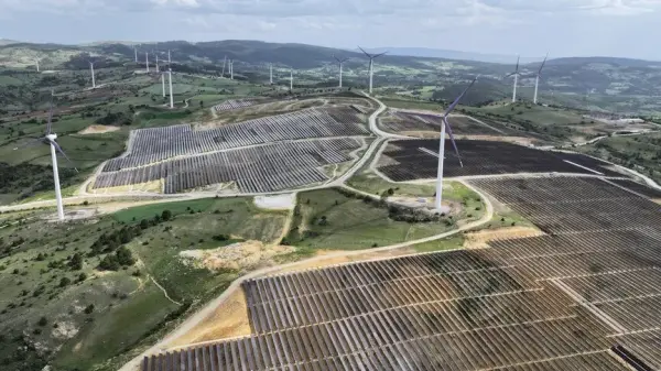 Güneş panelleri ve rüzgar türbinlerinin yer aldığı geniş bir yenilenebilir enerji santrali