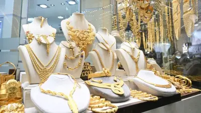 Bir kuyumcunun büyüteçle altın incelediği görsel