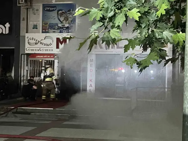 Manisa Yunusemre'de medikal ürünler satan bir iş yerinde çıkan yangına müdahale eden itfaiye ekipleri ve tahliye edilen apartman sakinleri.