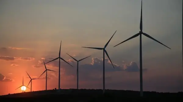 Rüzgar türbinleri ve güneş panelleri ile donatılmış bir enerji santralinin gerçekçi basın fotoğrafı.