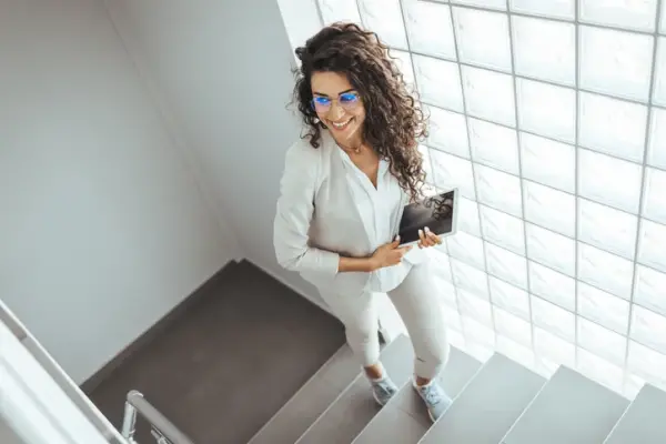 Bir kişinin modern bir binada merdiven çıkarken çekilmiş gerçekçi fotoğrafı