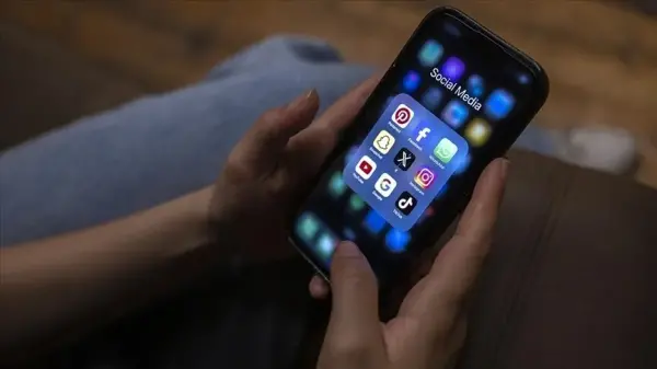 Bir çocuğun akıllı telefonuna bakarken düşünceli hali, sosyal medyanın etkilerini simgeliyor.