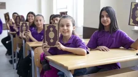 Öğrencilere Kur'an-ı Kerim hediye eden TDV yetkilileri