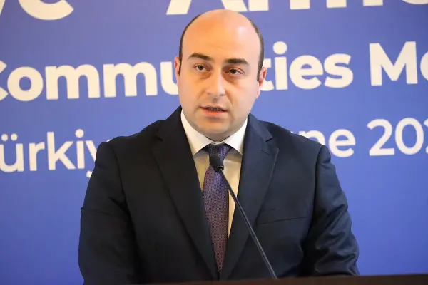 Türkiye ve Ermenistan bayrakları ve iş dünyası temsilcilerinin yer aldığı Kars'taki toplantı.