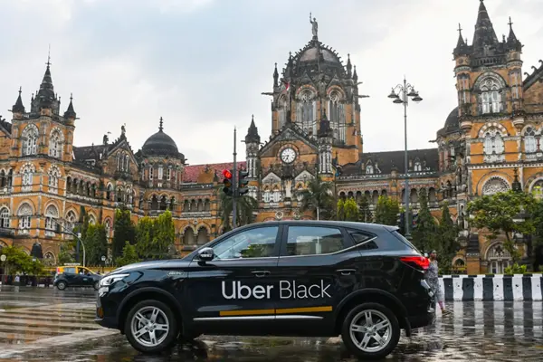 Uber ve Carrum Mobility yöneticilerinin Hindistan'daki yatırım anlaşmasını temsil eden bir görsel